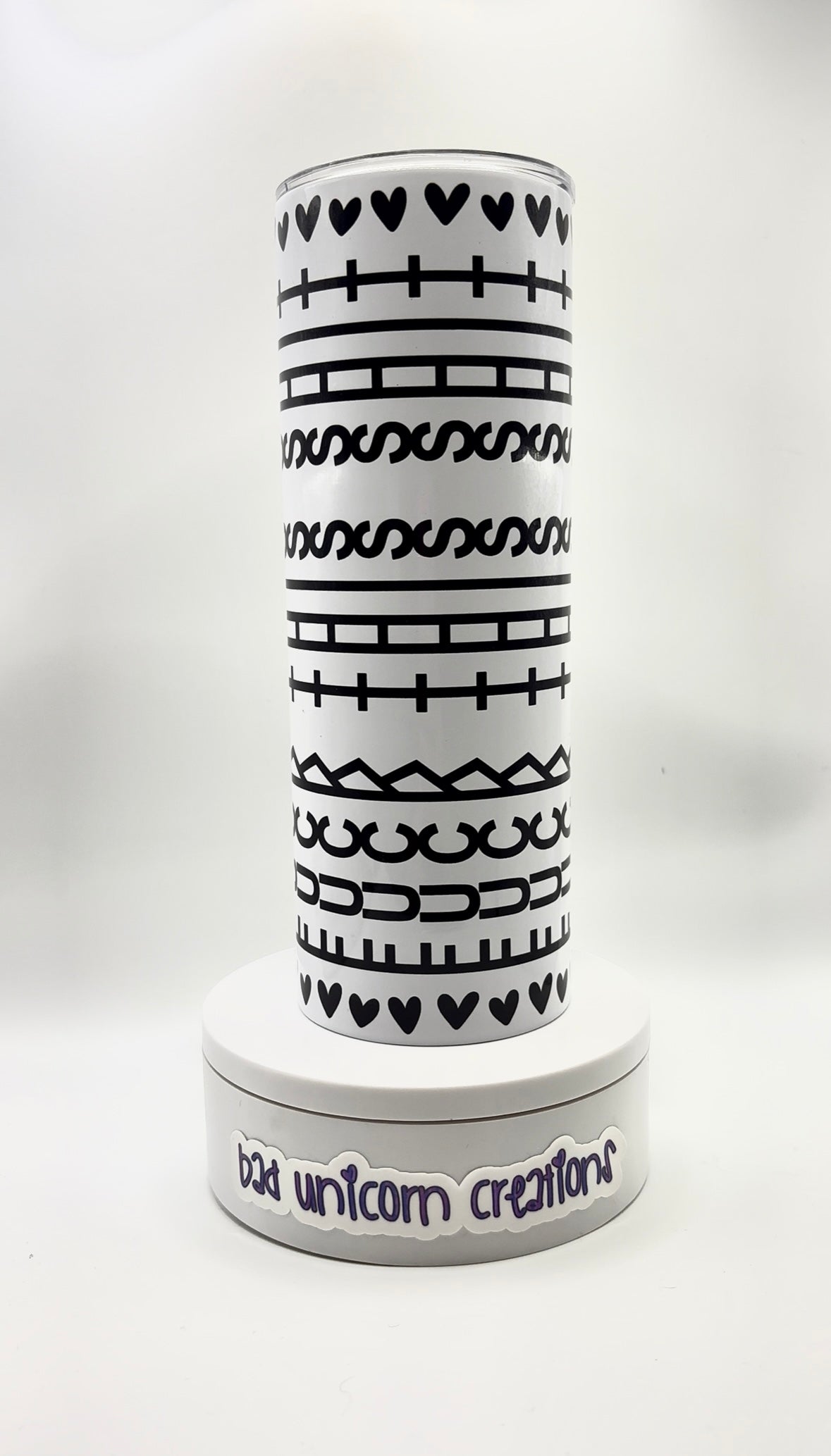 White tumbler with black printed hidden message and hearts.