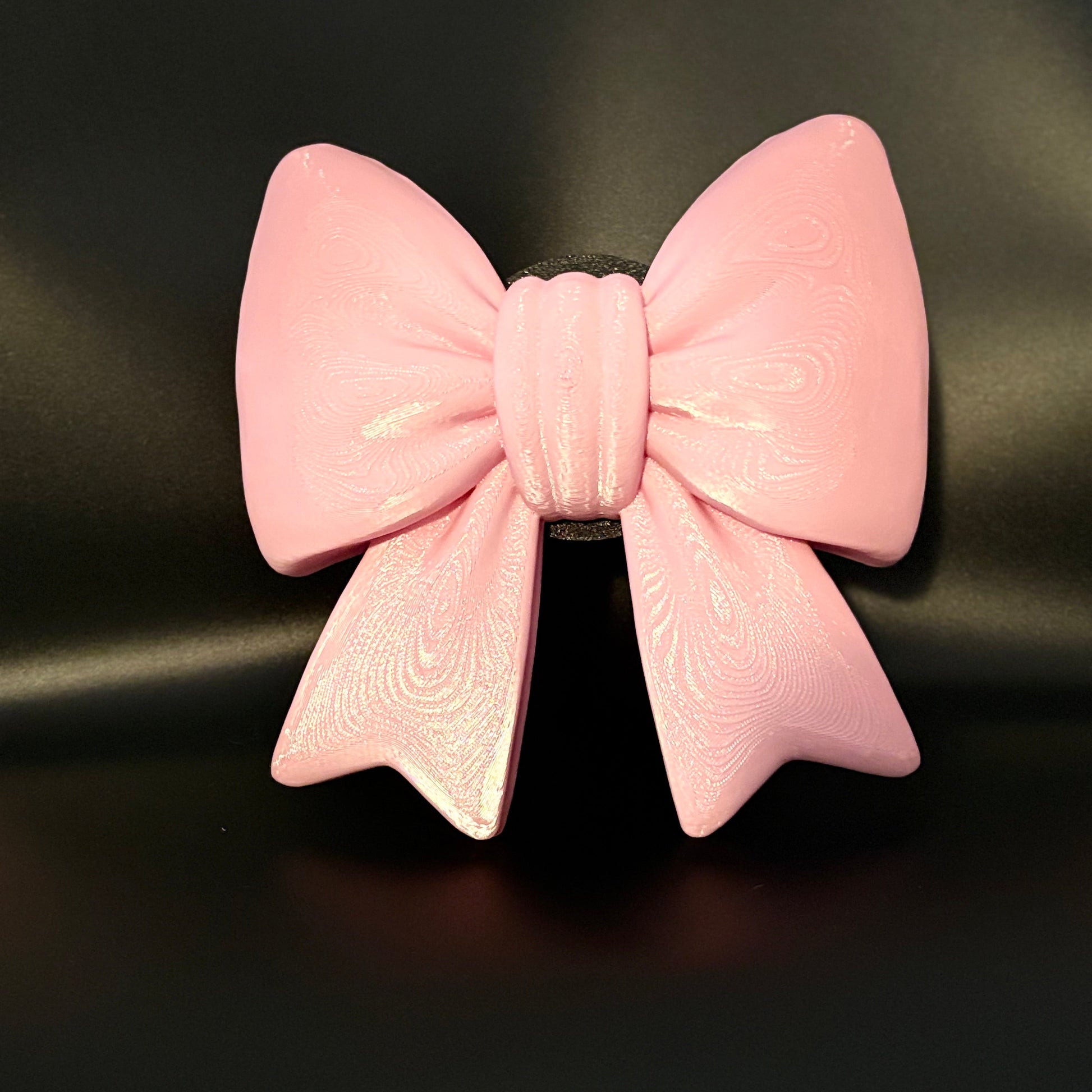 A light pink bow tow hitch cover